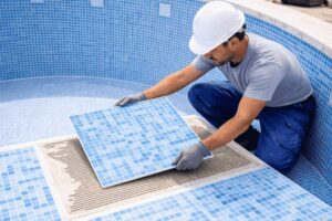 instalador con plancha de gresite en piscina